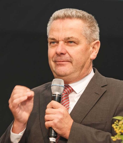 Bild: Das Bild zeigt Gerhard Hugenschmidt mit einem Mikrofon in der Hand.